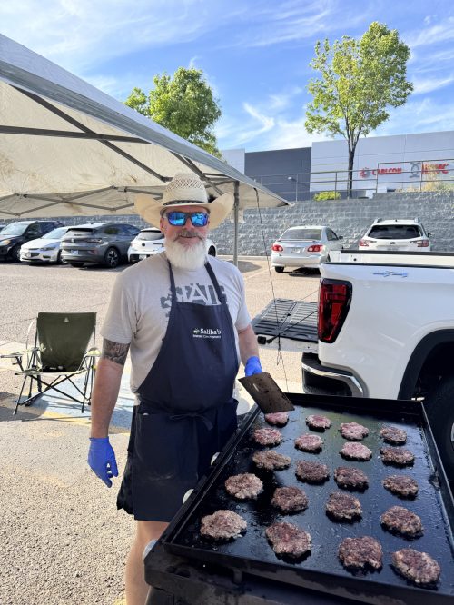 Man cooking burgers on a flat top grill