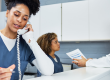 Nurse on phone while doctor and other nurse talk behind her.