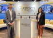 Two people standing at a Guardian Pharmacy podium